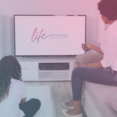 Woman and daughter watching TV with Life Network for Women logo on screen